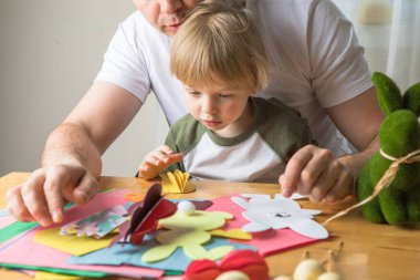 Baba ve 3 yaşındaki oğlu evde birlikte paskalya tavşanı yapıyorlar.