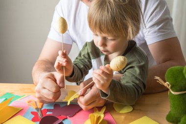 Baba ve 3 yaşındaki oğlu evde birlikte paskalya tavşanı yapıyorlar.