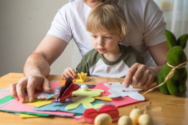 Baba ve 3 yaşındaki oğlu evde birlikte paskalya tavşanı yapıyorlar.