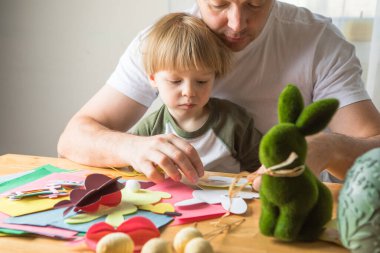 Baba ve 3 yaşındaki oğlu evde birlikte paskalya tavşanı yapıyorlar.
