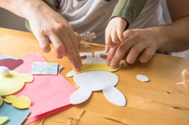 Baba ve 3 yaşındaki oğlu evde birlikte paskalya tavşanı yapıyorlar.