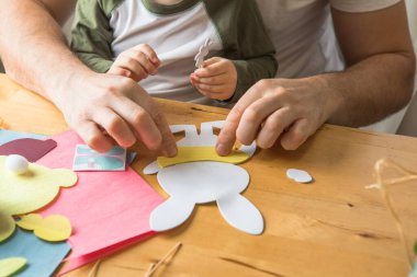 Baba ve 3 yaşındaki oğlu evde birlikte paskalya tavşanı yapıyorlar.