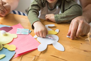 Baba ve 3 yaşındaki oğlu evde birlikte paskalya tavşanı yapıyorlar.