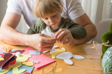 Baba ve 3 yaşındaki oğlu evde birlikte paskalya tavşanı yapıyorlar.