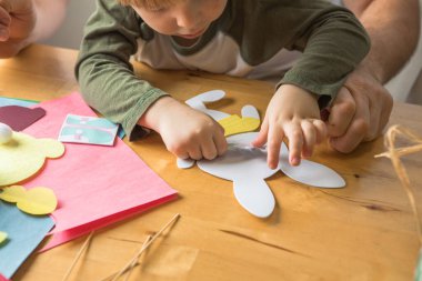 Baba ve 3 yaşındaki oğlu evde birlikte paskalya tavşanı yapıyorlar.