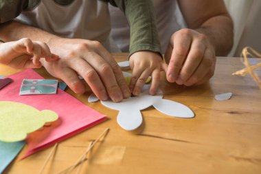 Baba ve 3 yaşındaki oğlu evde birlikte paskalya tavşanı yapıyorlar.