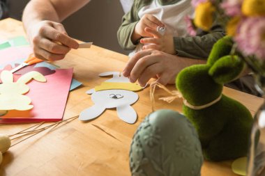 Baba ve 3 yaşındaki oğlu evde birlikte paskalya tavşanı yapıyorlar.