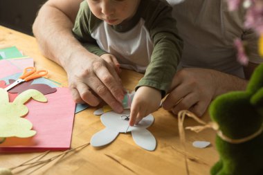 Baba ve 3 yaşındaki oğlu evde birlikte paskalya tavşanı yapıyorlar.