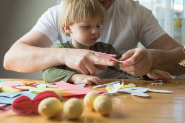 Baba ve 3 yaşındaki oğlu evde birlikte paskalya tavşanı yapıyorlar.