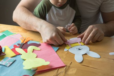 Baba ve 3 yaşındaki oğlu evde birlikte paskalya tavşanı yapıyorlar.