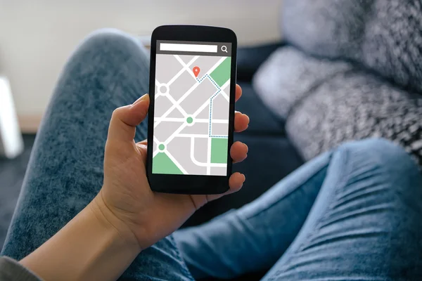 Дівчина тримає смартфон із додатком навігації gps на карті — стокове фото