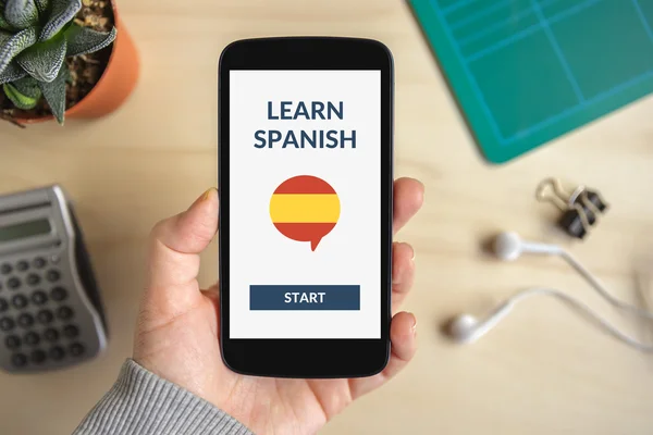 Hand holding smart phone with online learn spanish concept on screen — Stock Photo, Image