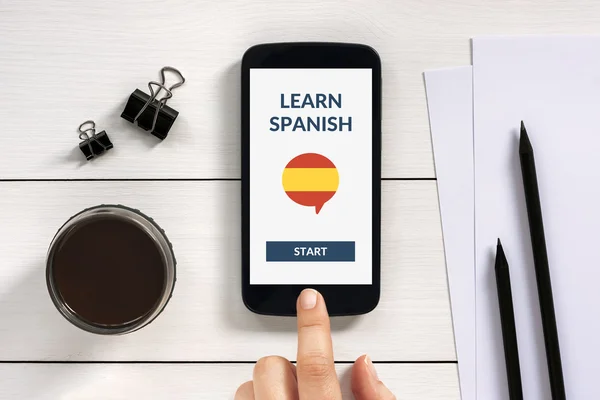 Aprender en línea concepto español en la pantalla del teléfono inteligente en escritorio de madera — Foto de Stock