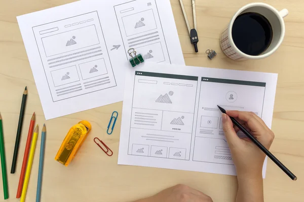 Tasarımcı Web sitesi wireframes ahşap masanın üzerinde çizim
