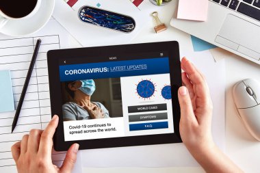 Eller Coronavirus 'un en son haber kavramına sahip dijital tablet bilgisayarı kullanıyor. Üst görünüm