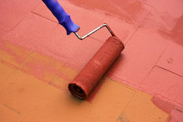 Contrato pintor pintando un piso con un rodillo de pintura — Foto de Stock