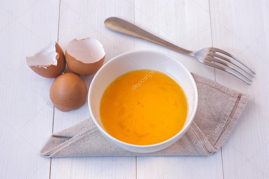 Beaten egg yolks in a bowl with fork 