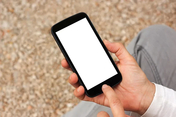 Manos sosteniendo el teléfono inteligente con pantalla vacía en blanco — Foto de Stock