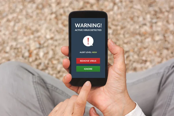Mains tenant smartphone avec alerte de virus à l'écran — Photo