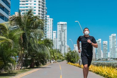 Şehirde dolaşan koruyucu maskeli bir adam. Spor, spor, yaşam tarzı konsepti