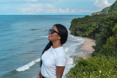 Plajda güneş gözlüklü zarif bir Afrikalı kızın portresi.