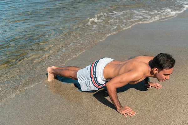 ヒスパニック男は午前中にビーチで運動 — ストック写真