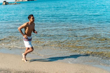 Sabahları plajda egzersiz yapan bir adam.