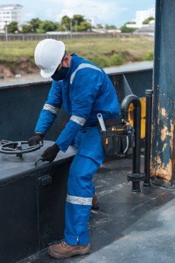Güverte subayı, bir deniz gemisinin güvertesinde, PPE kişisel koruyucu ekipmanlarıyla. İş yapıyorum. Denizde kağıt