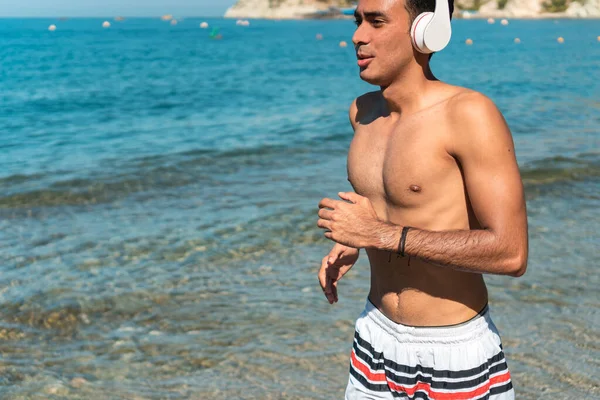 Young Latino Runner Running Beautiful Seashore While Listening Music Headphones — Stock Photo, Image