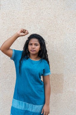 Kızgın ve cesur genç Afrikalı kadın yumruğuyla ayağa kalktı. Karışık ırk: Kadın feminist aktivist lider kadın hakları, cinsiyet eşitliği, güçlendirme amaçlı protesto konsepti için mücadele ediyor.