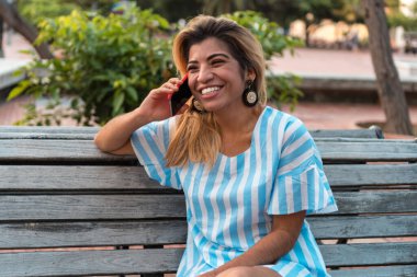 Tatildeki genç Latin turist şehrin akıllı telefonuyla konuşuyor.