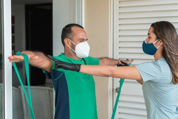 Hareket egzersizleri yapan yaşlı hastalarla çalışan fizyoterapist.