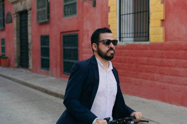 E- scooterlı İspanyol bir adam işe gidiyor, aceleyle.