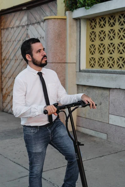 街の歩道にE Scooterで立っているビジネスマン — ストック写真
