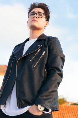 Düşünceli bir gencin yakın plan fotoğrafı. Olay yerinden uzağa bakıyor.