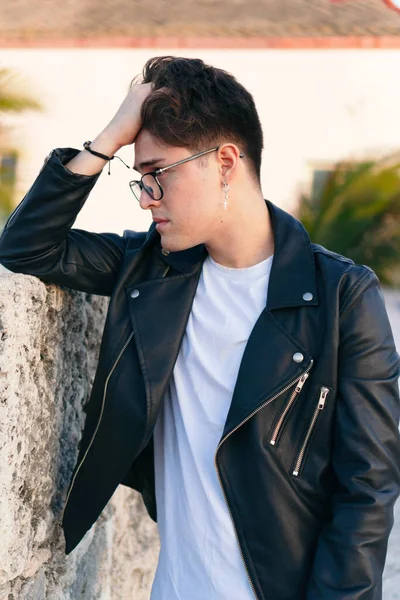 Kafası dışarıda oturan üzgün genç adamın yakın plan portresi.