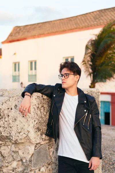 Açık havada gözlüklü, ciddi bir gencin yakın çekimi.