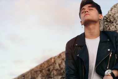 Kolombiya, Cartagena 'da bir parkta yakışıklı bir Latin. Çocuk yansıtıcı ve rahatça düşünüyor. Modern ve çağdaş kıyafetler.