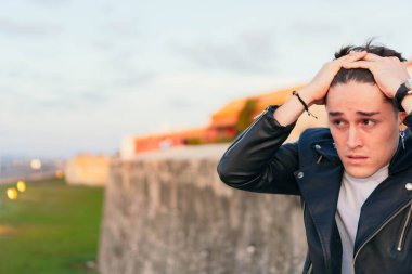Açık havada üzgün, yakışıklı genç bir adam. Umutsuzluk ve depresyon kavramı