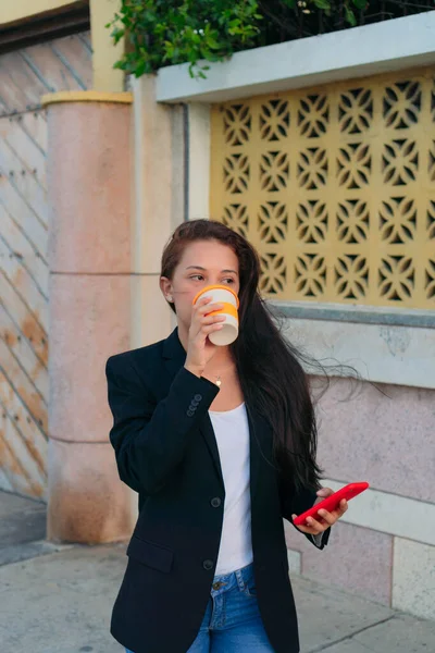 Joven Ejecutiva Bebiendo Café Sosteniendo Teléfono Celular Mientras Está Parada —  Fotos de Stock