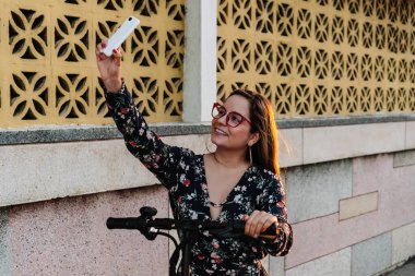 Mobiletle selfie çeken bir kadın. Çevre dostu ulaşım kavramı