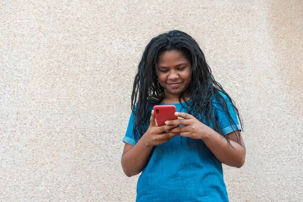 Afro woman writing a cell phone message