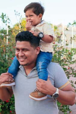 Bebek, babası tarafından taşınırken şeker yiyor.