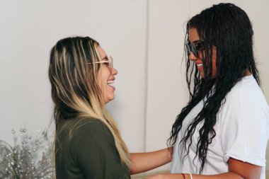 Two young Latina friends enjoy a day at home