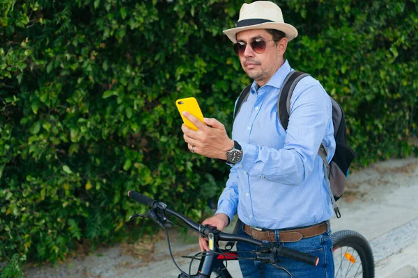 市内で自転車に乗っている間に携帯電話をチェックする男 — ストック写真