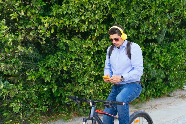 自転車に乗りながら携帯電話で音楽を聴いていた40歳の男性 — ストック写真