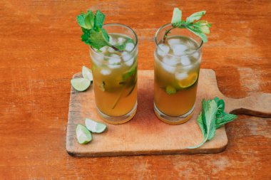 Limonlu mojito kokteyli ve tahta bir tahtanın üzerinde nane şekeri. Yaz içeceği.