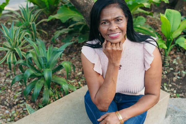 Olgun kadın parkta dinleniyor.