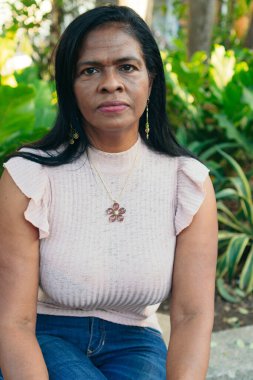 Parkta poz veren 50 'li yaşlarda bir kadının yakın çekimi.