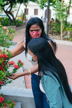 Parkta yüz maskesi takan Afrikalı anne ve kız